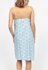 Abito azzurro chiaro con motivi circolari in bianco e blu scuro. Spalline sottili e design a lunghezza ginocchio. Tessuto dalla consistenza liscia.