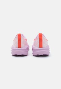 Lila Laufschuhe verfügen über ein strukturiertes Mesh-Obermaterial mit rosa Akzenten und einer leuchtend roten Fersenschlaufe. Dicke, gepolsterte Sohlen erhöhen den Komfort.