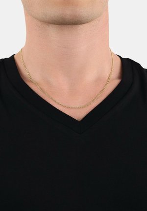 Collier en chaîne dorée avec un design à maillons plats reposant sur le cou d'une personne, associé à un t-shirt noir en v. Style simple et minimaliste.