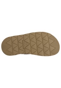Sole of a shoe with a rubber material, featuring a tan color and a diamond tread pattern for improved grip. "Clarks" logo visible.