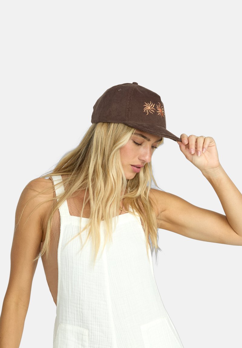 Cappello in corda marrone con visiera piatta, caratterizzato da un intricato ricamo arancione a forma di sole sulla parte anteriore. Sullo sfondo c'è un grigio semplice.