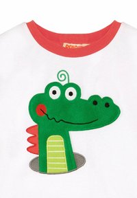 Biała koszulka z czerwonym kołnierzykiem, z zielonym projektem krokodyla z uśmiechniętą twarzą, paskami i teksturowanym detalem aplikacji.