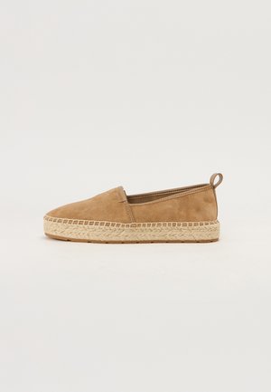 Scarpa slip-on in suede marrone con suola in juta intrecciata. Presenta una punta arrotondata e un piccolo anello posteriore per un facile indosso.