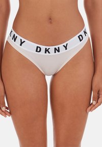 Perizoma beige con ampia fascia elastica bianca con marchio nero "DKNY", tessuto liscio e taglio a vita bassa.