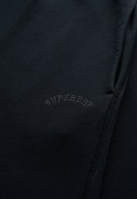 Zwarte katoen sweatshirt met een verhoogd "SUPERDRY" logo in een semi-arced ontwerp. Gladde textuur met zichtbare stikdetails.