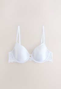 Reggiseno imbottito bianco con spalline regolabili e dettagli in pizzo sui lati, mostrato disteso su uno sfondo chiaro.