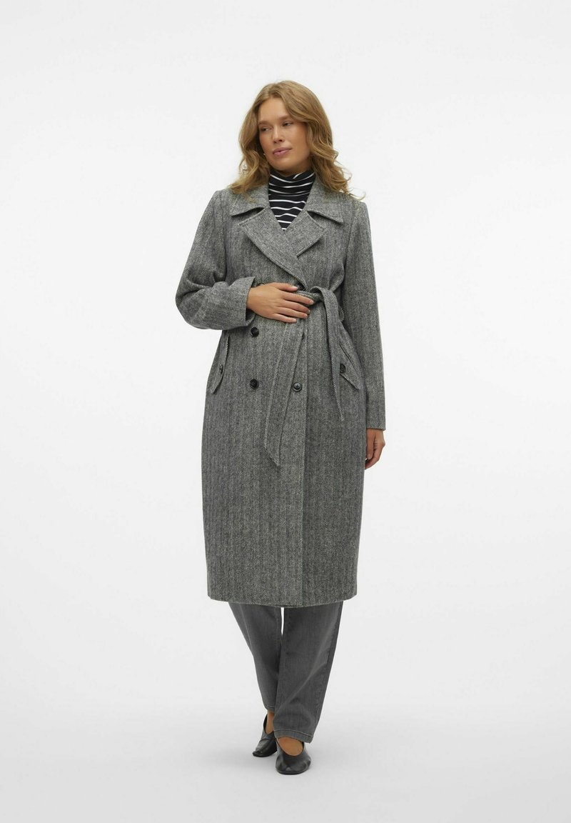 Manteau en laine gris, long, avec une taille ceinturée, un devant à double boutonnage et des revers crantés. Tissu texturé avec des rayures verticales.