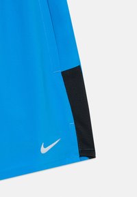 Nike atletske kratke hlače u vibrantnoj plavoj boji s crnim mrežastim detaljima, glatka tkanina, kontrastna šavova i srebrni logo na donjoj lijevoj strani.