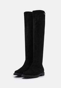 Botas negras hasta la rodilla hechas de ante con suela de goma plana. Textura suave y diseño minimalista, sin hardware o acentos prominentes.