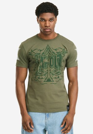 Olijfgroene T-shirt met korte mouwen, gemaakt van katoen, met een grote groen-zwarte grafische print op de voorkant en logodetail op de mouwen.