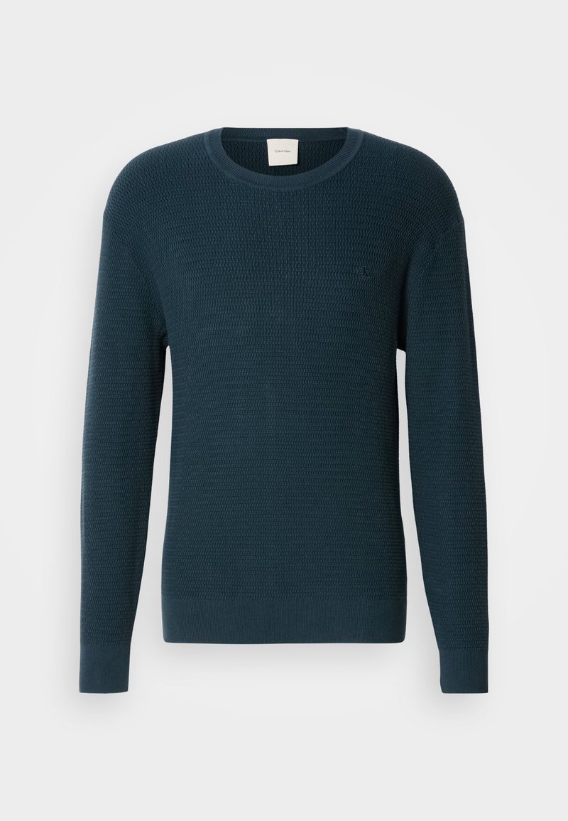 Dark teal knitted sweater with a round neckline, long sleeves, and textured pattern. Features a small logo on the chest.