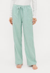 Pantaloni da pigiama verde chiaro con strisce verticali bianche, dotati di una vita elastica con cordoncino e un design rilassato e a gamba larga.