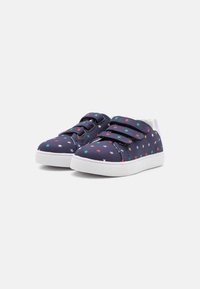 Pantofi sport din pânză cu o bază albastră închisă, având un model cu stele multicolore, talpă din cauciuc alb și două benzi de Velcro pentru închidere.