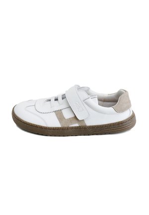 Zapatilla blanca casual con detalles en ante beige, tira de velcro, detalles de cordones y suela de goma marrón texturizada, mostrada de perfil.