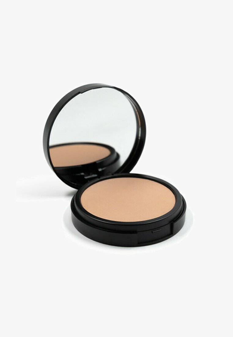 Polvere compatta con una superficie beige liscia, racchiusa in un astuccio rotondo nero con specchio. La custodia esterna è minimalista e lucida.