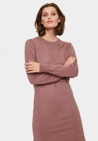 Bordo obleka z dolgimi rokavi, okroglim izrezom in mehkimi tkaninami. Ima rahlo napihnjene ramena in raven, sproščen kroj.