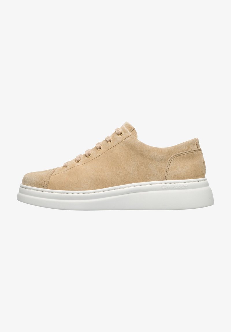 Baskets en suède beige avec un bout arrondi, semelle blanche plate et six oeillets. Présente une couture minimale et une texture lisse.