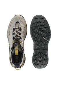 Jasnoszare buty trekkingowe GORE-TEX z czarnymi sznurówkami, teksturowaną gumową podeszwą i zielonymi akcentami. Posiadają pętlę do ściągania oraz solidną konstrukcję do użytku na zewnątrz.