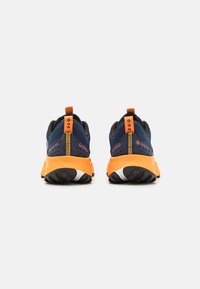 Blue and black shoes with orange accents, textured mesh upper, Gore-Tex branding, and a flexible rubber sole with distinct tread pattern.