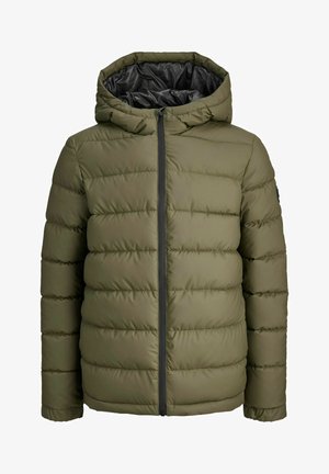 Veste doudoune verte avec un design matelassé et une capuche, portée par-dessus un t-shirt noir, associée à un pantalon de sport noir et des baskets grises.