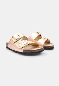 Rose gold sandals with two buckled straps, a cork footbed, and a black outsole. Smooth textured upper with metallic finish.