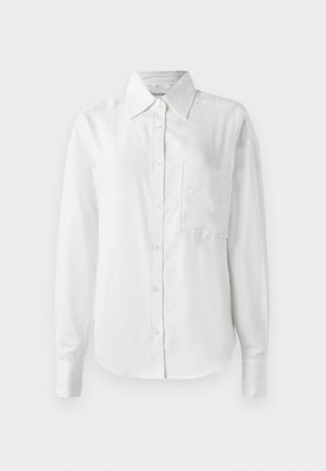 Camisa blanca de manga larga con botones, hecha de una tela suave, presenta un cuello puntiagudo, un bolsillo frontal y puños con botones para un aspecto a medida.