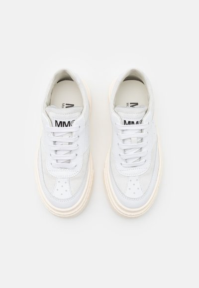 Hvite lær sneakers med kremfargede gummisåler, med en avrundet design, snøring og subtile perforeringer på tåen.