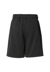 Fekete melegítősort rugalmas derékpánttal, puha anyagból és laza szabással. Egyszerű varrással és sima tapintással rendelkezik.