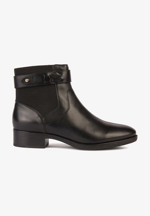 Stivale alla caviglia nero in pelle liscia, con pannello laterale elastico e una cintura decorativa con accentuazione dorata. Tacco basso impilato.