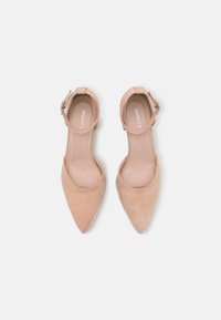 Nude suede high heel shoes with a pointed toe, ankle strap featuring a silver-tone buckle, and smooth inner lining.