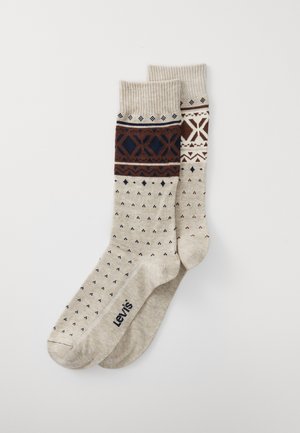 Beige patterned socks featuring navy, brown, and white designs. Textured ribbed cuffs with contrasting diamond and dot patterns. Brand logo visible.