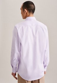Camicia button-up lavanda in tessuto morbido, maniche lunghe e orlo curvo. Presenta pince sul retro e polsini con bottone.