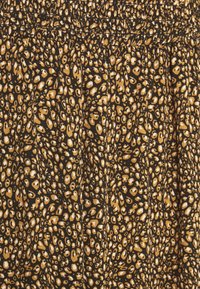 Musta kangas, jossa on kultainen ja valkoinen eläinkuosikuvio, jossa on poimutettu pinta. Suunnittelussa on sileä ja kevyt ulkonäkö.