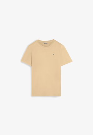 Camiseta beige de manga corta con cuello redondo y pequeño logo oscuro de calavera y huesos cruzados en el lado izquierdo del pecho, colocada plana sobre un fondo blanco.