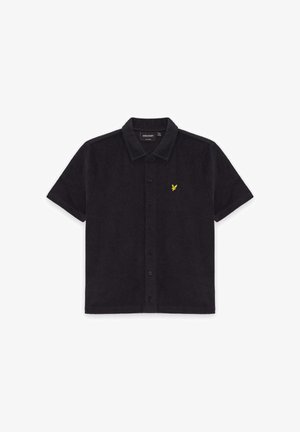 Chemise noire à manches courtes avec col et boutons, présentant un petit logo d'aigle jaune sur la poitrine gauche et une étiquette Lyle & Scott à l'intérieur du col.