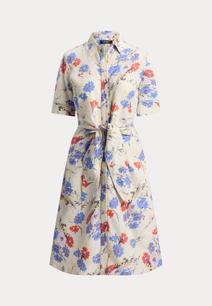 Φλοράλ φόρεμα-πουκάμισο με κοντά μανίκια· διαθέτει κουμπιά μπροστά, ζώνη στη μέση, και ύφασμα ανοιχτό μπεζ με κόκκινα, μπλε και κίτρινα λουλούδια.