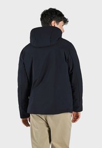 Giacca blu navy con cappuccio imbottito, texture liscia e dettagli con zip nascosta; vestibilità sagomata e design elegante.