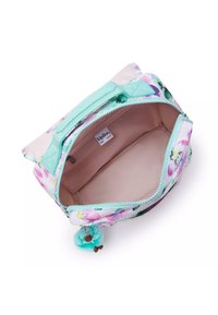 Trousse de maquillage à motif floral avec une fermeture éclair vert menthe, un intérieur rose clair et un charm en fourrure teal attaché à la tirette.