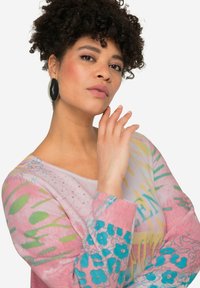 Maglione colorato a maniche lunghe caratterizzato da un mix di motivi floreali e astratti in tonalità pastello, con accenti di turchese e giallo.