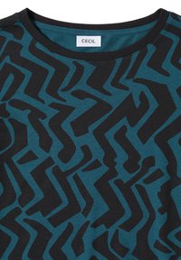 Turquoise T-shirt met een zwart abstract zigzagpatroon, voorzien van een ronde halslijn en gemaakt van zacht katoen. Het label vermeldt "CECIL".