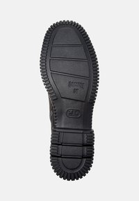 Suola di scarpa in gomma nera con un motivo testurizzato e il nome del marchio "Camper" insieme al numero di modello "38."