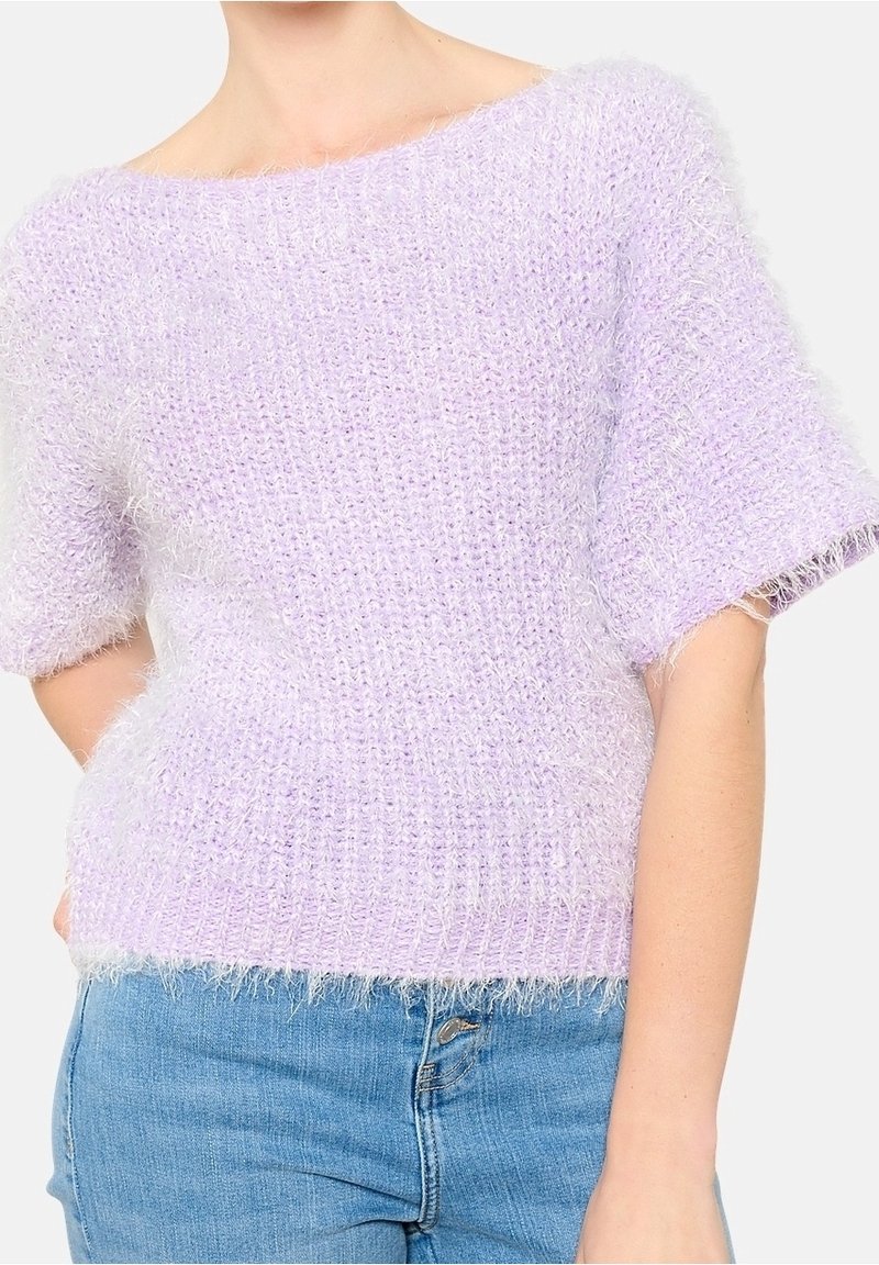 Lila neulepaita lyhyillä hihoilla, jossa on rento istuvuus ja tekstuuri, pörröinen pinta. Reunoissa on raakaleikkuun kaltainen häntä.
