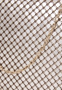 Tela de malla metálica con patrón hexagonal en tonos plateados y beiges, que presenta una cadena dorada que recorre la superficie.