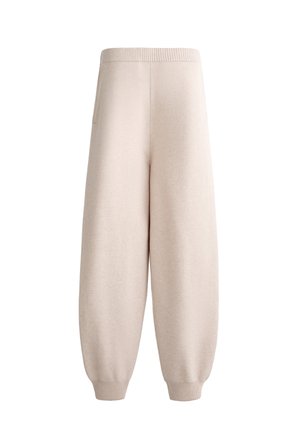 Beige, soft knit pants with a relaxed fit, ribbed waistband, and elastic cuffs. Features side pockets and a tapering silhouette.