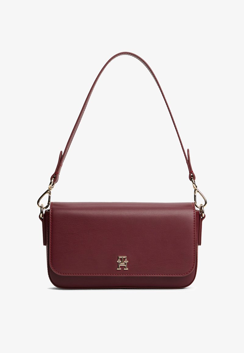 Burgundowa skórzana torba na ramię z pojedynczym paskiem, złotymi akcentami i przednią klapą z wytłoczonym logo. Gładka faktura z minimalistycznym designem.