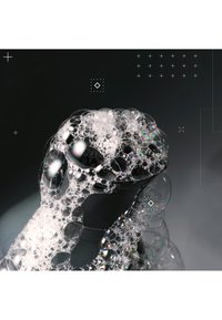 Transparent tvålbubblor klustrar över en svart yta och visar intrikata mönster och reflexer, med varierande storlekar och texturer.