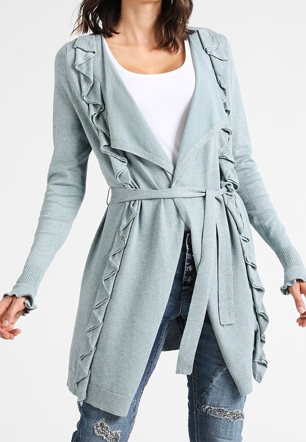 Cardigan bleu clair avec des bords ondulés, ouverture à l'avant, manches longues et une ceinture nouée à la taille. Fabriqué en matériau tricot doux.