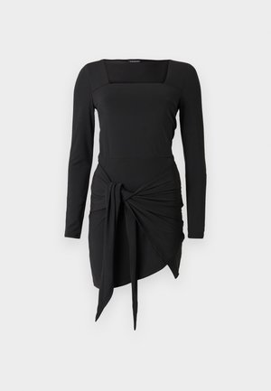 Robe noire à manches longues avec un décolleté carré, dotée d’un nœud décoratif à la taille et d’un ourlet asymétrique. Texture lisse.