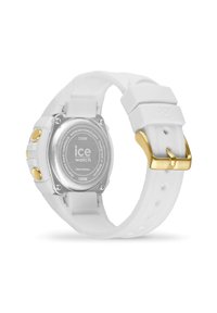 Montre en silicone blanche avec un boîtier arrière rond en acier inoxydable argenté, accents en métal doré et un bracelet ajustable robuste. Étanche jusqu'à 100 mètres.
