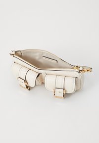Cream leather handbag with a textured finish, gold hardware accents, and a zippered top. Features small exterior pockets and a smooth interior.